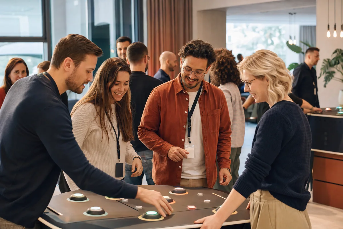 Kolleginnen und Kollegen an einer interaktiven Spielstation bei einem Firmenevent